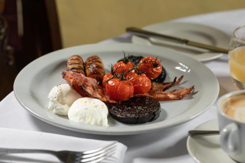 a plate of food on a table with eggs and bacon at The Griffin Inn in Fletching