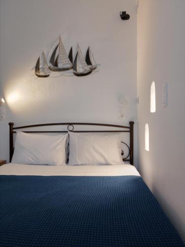 ein Schlafzimmer mit einem Bett mit zwei Segeln an der Wand in der Unterkunft Meltemi Rooms and Studios in Anafi