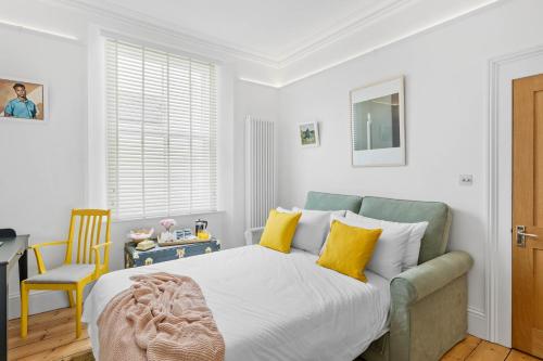 a bedroom with a large bed with yellow pillows at Hoe Park House, Sleeps 10, Historic, Central, Near Excellent Dining, Bars & Seafront in Plymouth