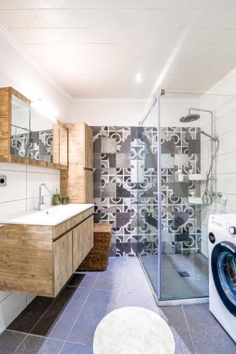 a bathroom with a sink and a washing machine at Moute House by Corfuescapes in Ágioi Doúloi