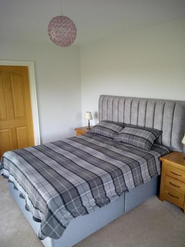 a bedroom with a bed with a checkered blanket at luxury in Ballyvoy