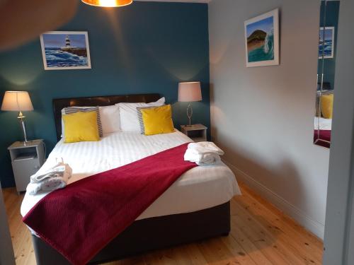 Un dormitorio con una cama con una manta roja. en Baywatch Inn, en Dingle
