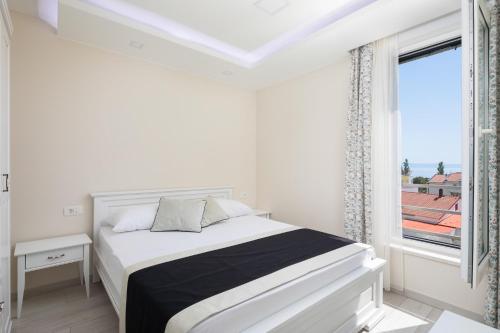a white bedroom with a bed and a window at Villa Jakov in Promajna