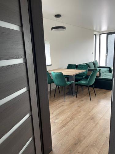 une salle à manger avec une table et des chaises vertes dans l'établissement Luxury Apartments, à Malý Slavkov