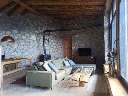 ein Wohnzimmer mit einem Sofa und einem Tisch in der Unterkunft 19th Century Neo-Modern KABAK VALLEY STONE HOUSE in Fethiye