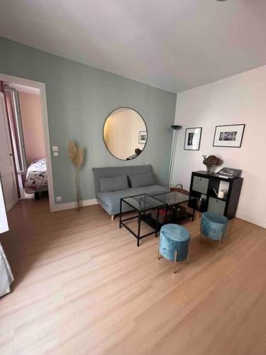 a living room with a couch and a mirror at Joli cocon proche de Paris centre in Boulogne-Billancourt