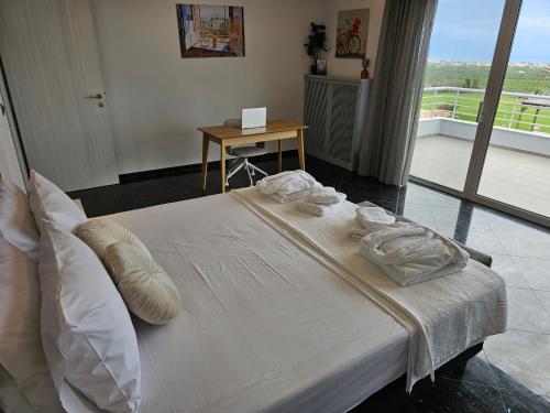 a white bed with towels on it in a room at Villa Dennis in Vrahati