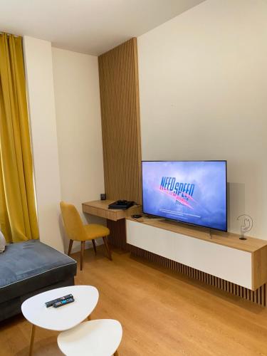 un soggiorno con TV a schermo piatto e divano di Уютен апартамент в сърцето на прекрасен град Варна a Varna