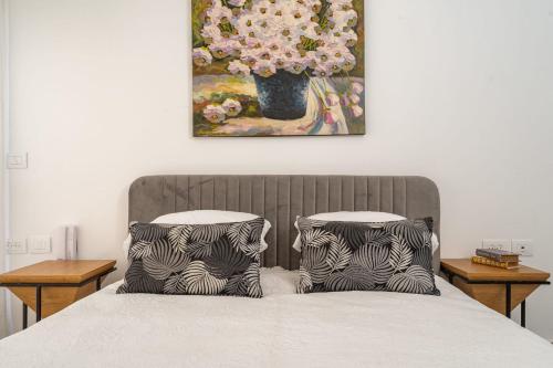 two pillows on a bed with a painting on the wall at Agrippas St 8 - Isrentals in Jerusalem