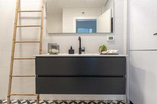 a kitchen with a black and white sink next to a refrigerator at Agrippas St 8 - Isrentals in Jerusalem