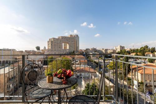 a table with a bowl of fruit on top of a balcony at Agrippas St 8 - Isrentals in Jerusalem