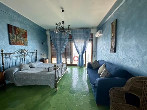 a blue bedroom with a bed and a couch at Sea Pearl in Casteldaccia