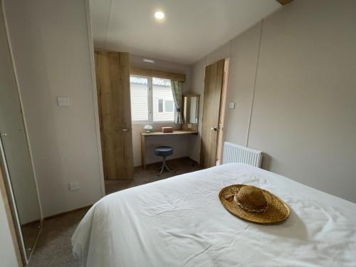 a straw hat sitting on a bed in a bedroom at Mersea Retreat in West Mersea