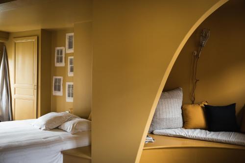 a room with a bed and a table with a window at pieuX in Montreuil-sur-Mer