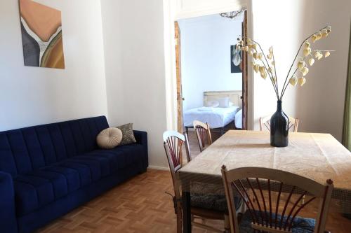 uma sala de estar com uma mesa e um sofá azul em Wonderer House in Batumi's Old City em Batumi
