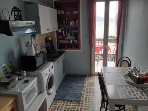 a kitchen with a washing machine and a table at Clock's House in Nafpaktos