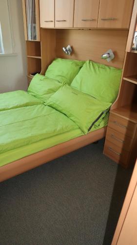 1 cama con sábanas verdes en una habitación en Happy 1 en Quierschied