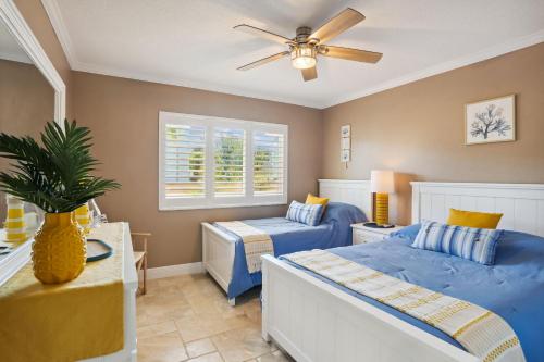 1 dormitorio con 2 camas y ventilador de techo en Land's End 7-203 Beach Front - Premier, en St Pete Beach