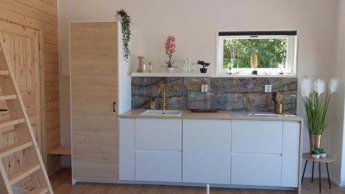 a kitchen with a counter and a window at Nieuw Tiny House met uitzicht op het Skagern meer in Finnerödja