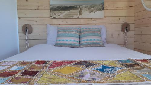 a bed with a quilt on top of it at Nieuw Tiny House met uitzicht op het Skagern meer in Finnerödja