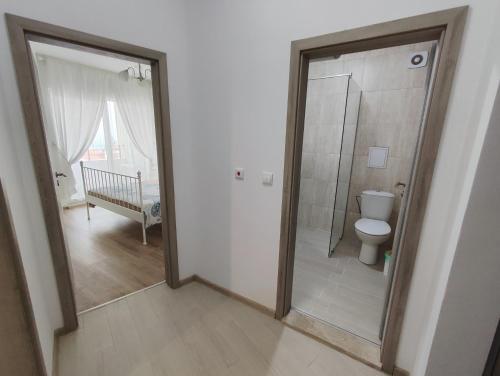 een badkamer met een toilet en een glazen douche bij Raya Central Obzor in Obzor