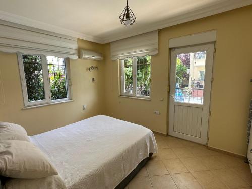 a bedroom with a white bed and windows at Villa Marla in Side