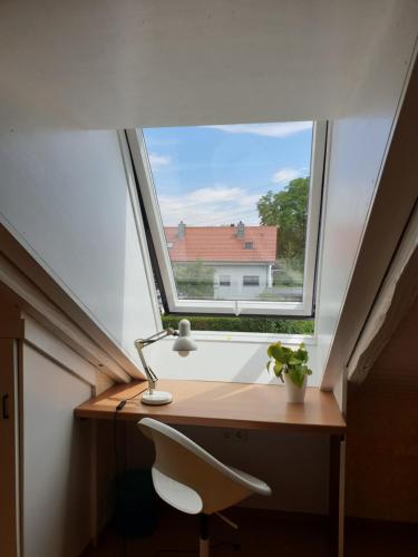 a window in a room with a desk and a chair at Sonnige ruhige Dachzimmer inkl WIFI plus Kaffee mit WG Dusche und neuer Küche in Lörrach