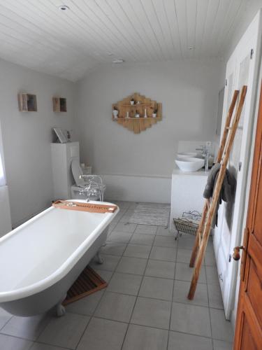 a bathroom with a large tub and a sink at Le Petit Couvent in Musculdy