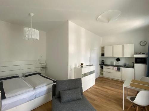 a white bedroom with a bed and a table at Apartment Nr. 3 Bad Laasphe Altstadt in Bad Laasphe