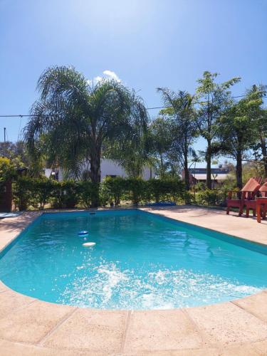 duży błękitny basen z drzewami w tle w obiekcie ALQUIMIA w mieście Paso de la Patria