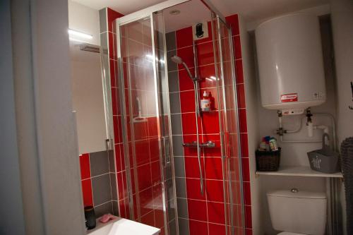 La salle de bains est pourvue d'une douche et de carrelage rouge. dans l'établissement atlantis, à Vannes