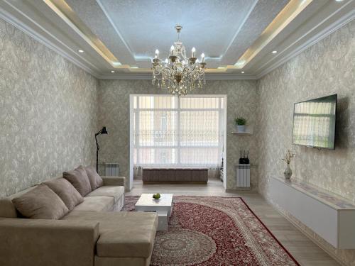 a living room with a couch and a chandelier at Large modern apartment mix style in Dushanbe