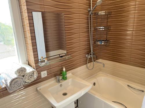 a bathroom with a sink and a bath tub at Large modern apartment mix style in Dushanbe