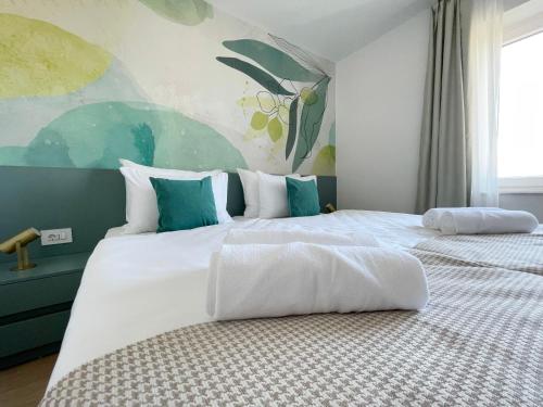 a bedroom with two beds and a painting on the wall at Villa Ardura - island holiday residence **** Bol. Island Brač in Bol