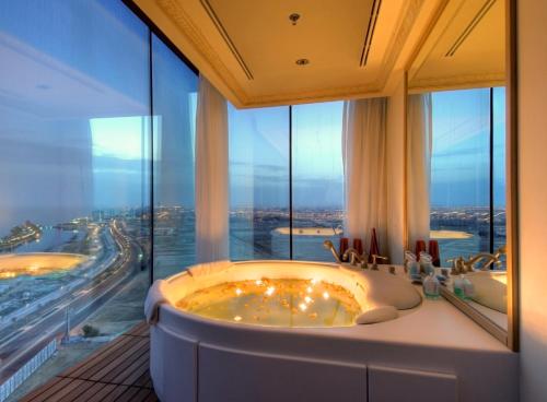 baño con 2 bañeras y ventana grande en Rosewood Jeddah en Yeda