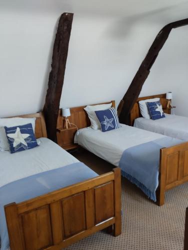 Cette chambre comprend 3 lits avec des draps bleus et blancs. dans l'établissement Le Manoir de la Pichardière, à Cherrueix
