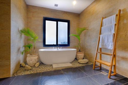 博卡拉的住宿－Dorje's Resort and Spa，浴室设有白色浴缸和2种植物