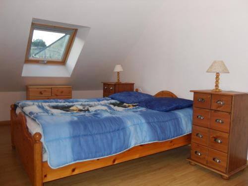 a bedroom with a bed with blue sheets and a dresser at Maison de Pecheur in Port-en-Bessin-Huppain