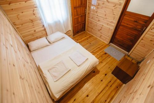 Cama pequeña en habitación con suelo de madera en Kadir's Family House, en Olympos