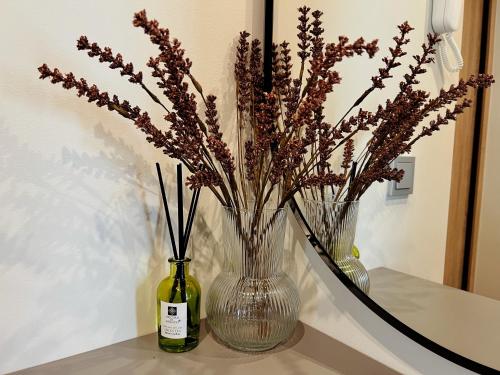 two vases with flowers in them sitting on a table at Cozy family apartment near the old town in Klaipėda