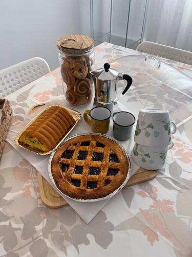 een tafel met een taart en een pastei erop bij Casetta Mia - Holiday Family House in Santarcangelo di Romagna