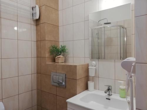 a bathroom with a sink and a mirror at Apartament Kapitalny in Dziwnówek