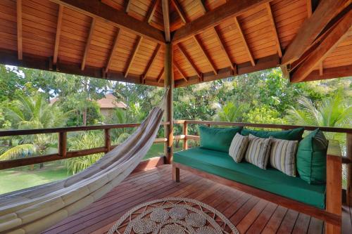 a hammock on a porch with a hammock at Anttunina Pousada e SPA in Maragogi