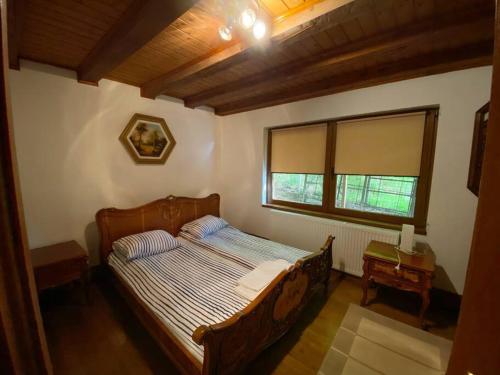 1 dormitorio con 1 cama en una habitación con ventana en Máréfalvi vendégház, en Băile Homorod