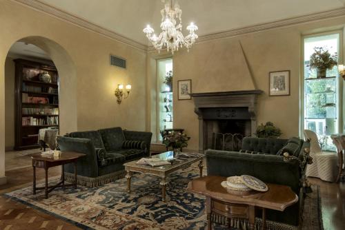 a living room with green furniture and a fireplace at Posta Donini 1579 - UNA Esperienze in San Martino in Campo