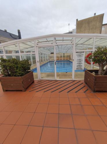 einen Pool in einem Gebäude mit zwei Topfpflanzen in der Unterkunft Apartamento Tamarisco in Foz