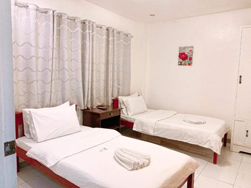 a hospital room with two beds and a window at Luna Oslob Travellers Inn in Oslob