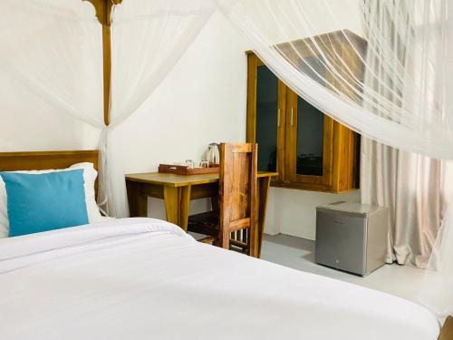 een slaapkamer met een bed, een tafel en een raam bij Rams Resort in Arugam Bay