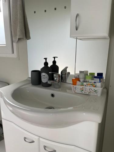 a white sink in a bathroom with bottles on it at Mobile Home L&L in Drage