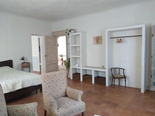 ein Schlafzimmer mit einem Bett und einem Stuhl in der Unterkunft Villa Amai in Lequio Tanaro